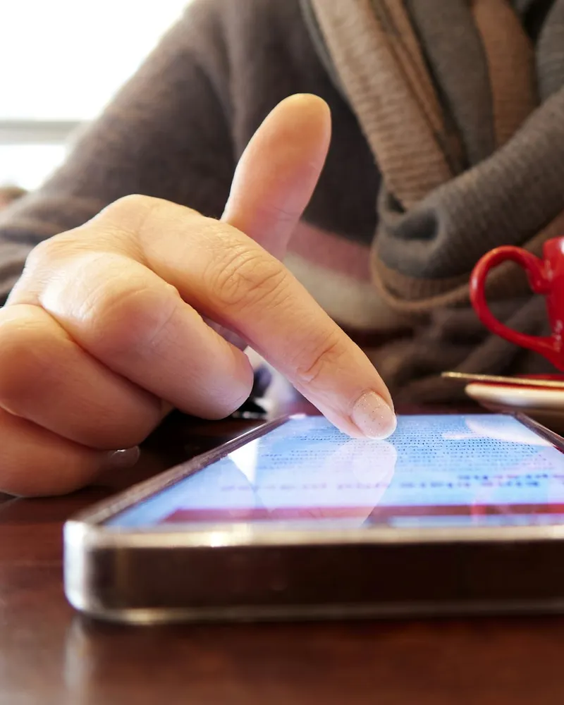 Smartphone mit geöffneter Website auf einem Holztisch